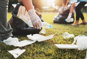 Image de deux personnes ramassant des déchets au sol afin d'illustrer notre article sur la gestion des déchets pendant les jeux olympiques 2024